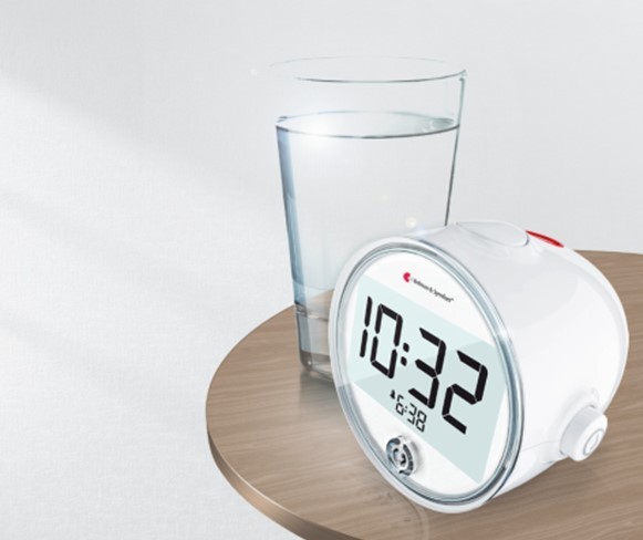 Bellman Classic Alarm Clock on the Table with A Glass of Water